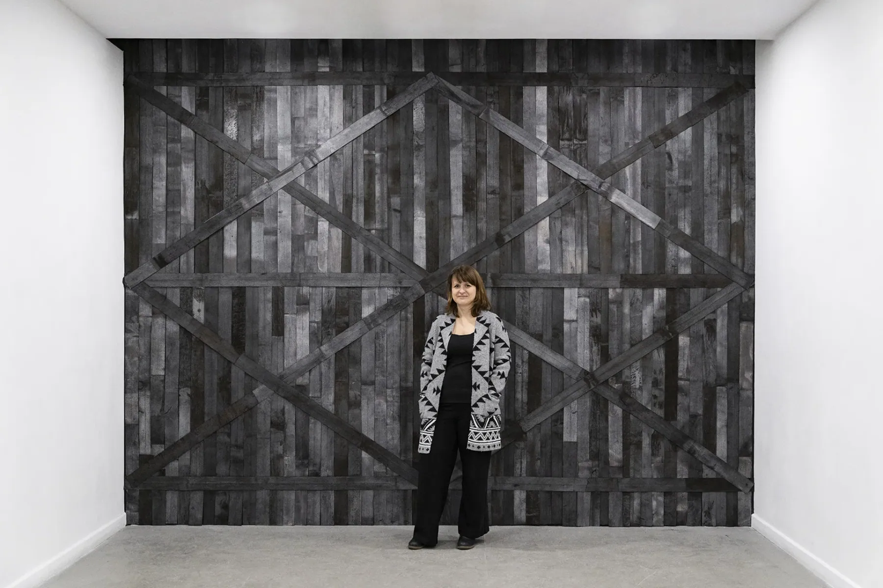 Monika Shaded standing in front of her wall installation Przejście (Passage)